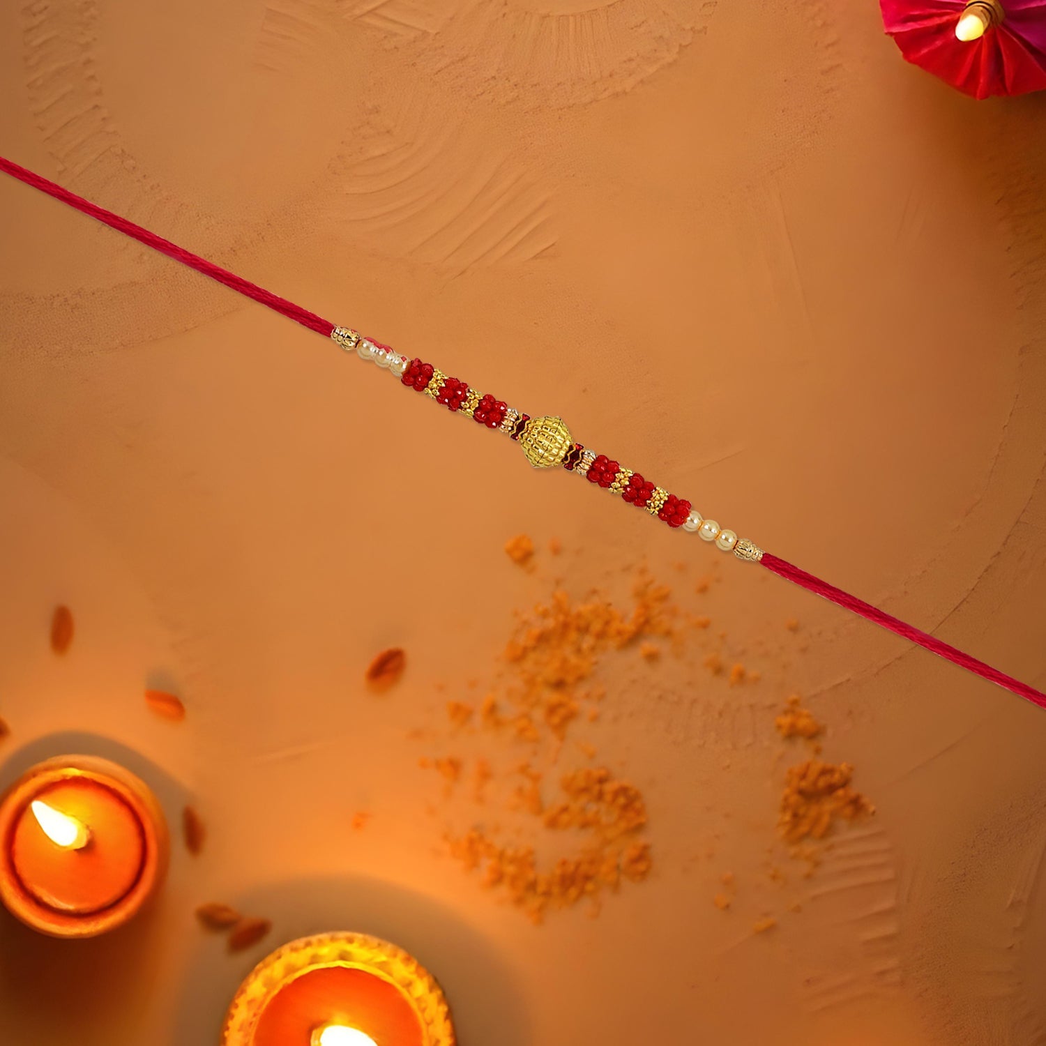 ALVENZA Red Bead Rakhi – Golden Centerpiece & Pearl Details