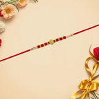 ALVENZA Red Bead Rakhi – Golden Centerpiece & Pearl Details