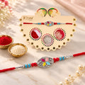 ALVENZA Silver Oval Floral Stone Rakhi with Color Petal Centre, Roli Chawal Coin and Card Packing