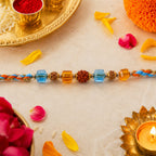 ALVENZA Blue Beaded Bracelet Rakhi with Golden Spacers and Colorful Festive Charm