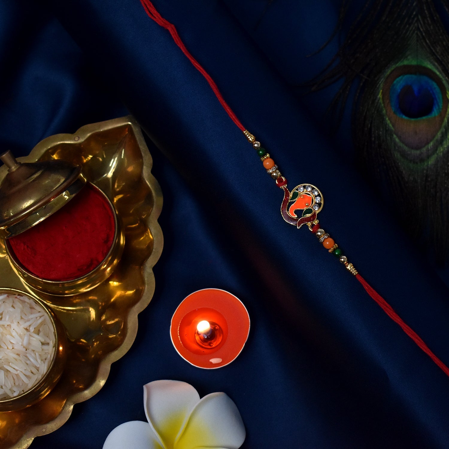 ALVENZA Golden Ganesha Rakhi – Red Green Beads with Stone Detailing