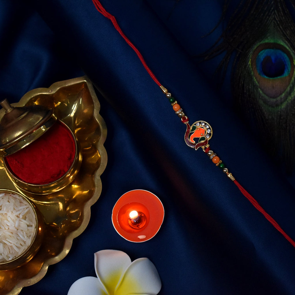 ALVENZA Golden Ganesha Rakhi – Red & Green Beads with Stone Detailing