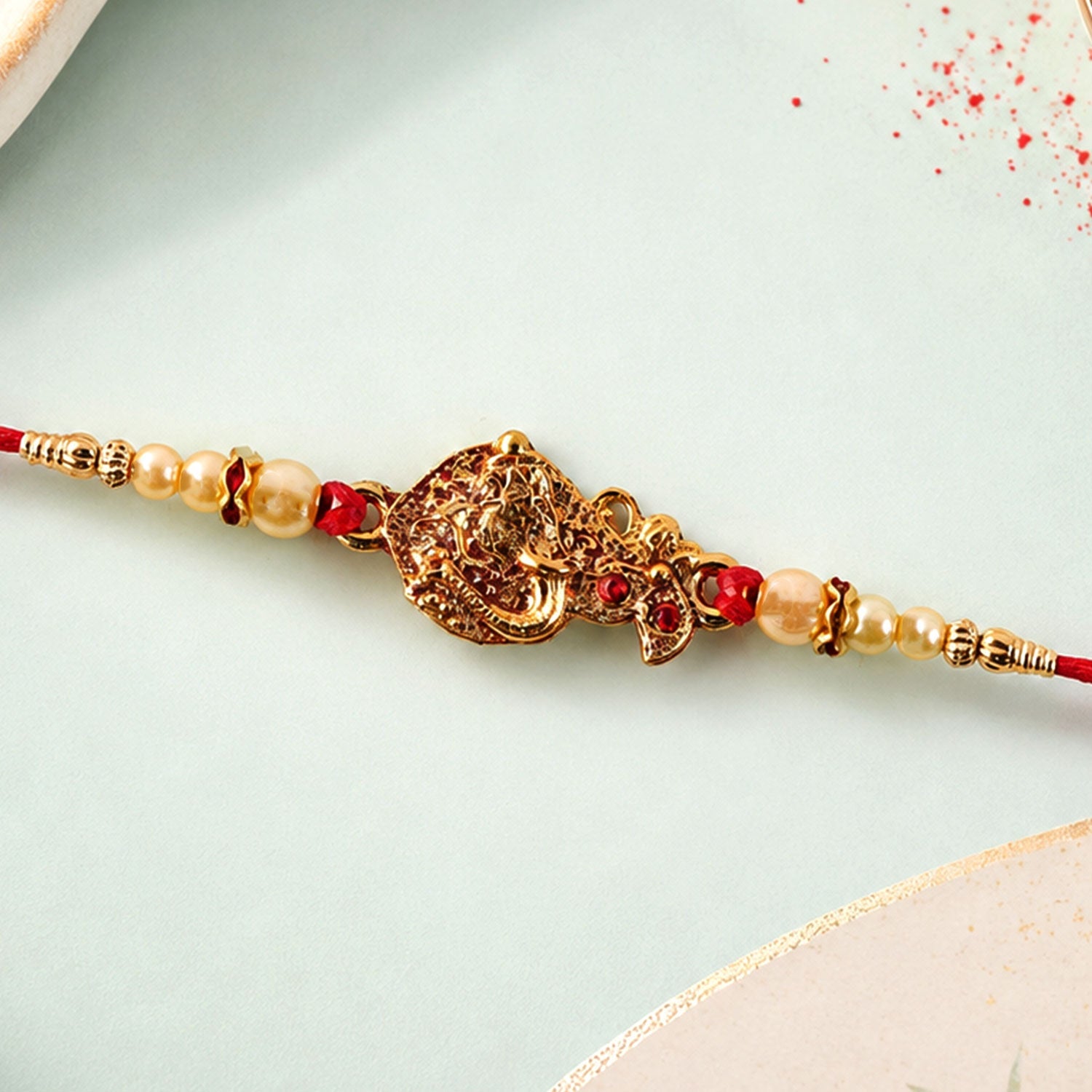 ALVENZA Golden Peacock Rakhi - Pearl Beads & Red Thread for Brother on Raksha Bandhan