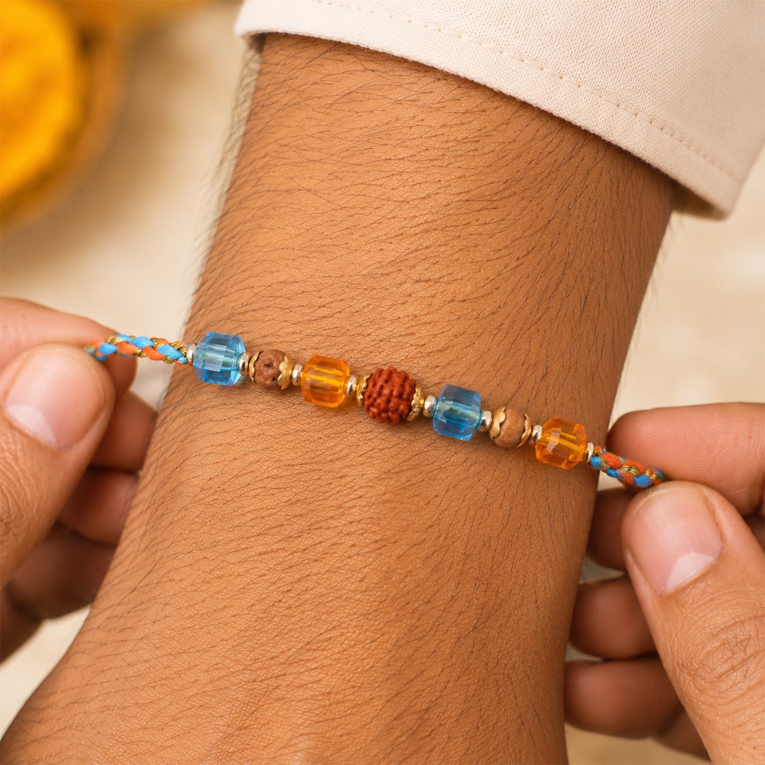 ALVENZA Blue Beaded Bracelet Rakhi with Golden Spacers and Colorful Festive Charm