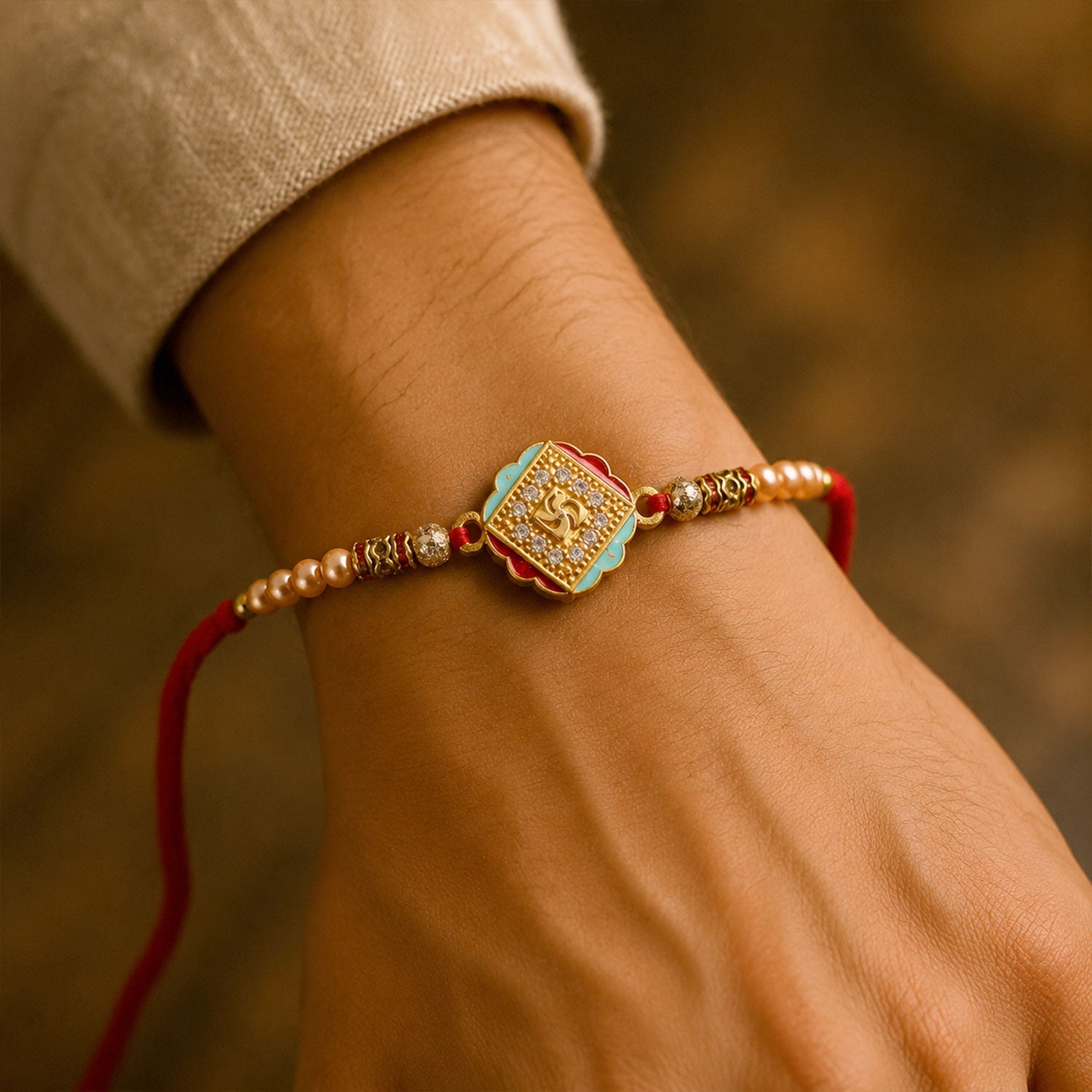 ALVENZA Golden Swastik AD Stone Rakhi with Turquoise-Red Meenakari and Pearl Beads