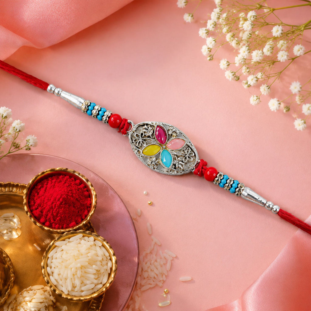 ALVENZA Silver Oval Floral Stone Rakhi with Color Petal Centre, Roli Chawal Coin and Card Packing