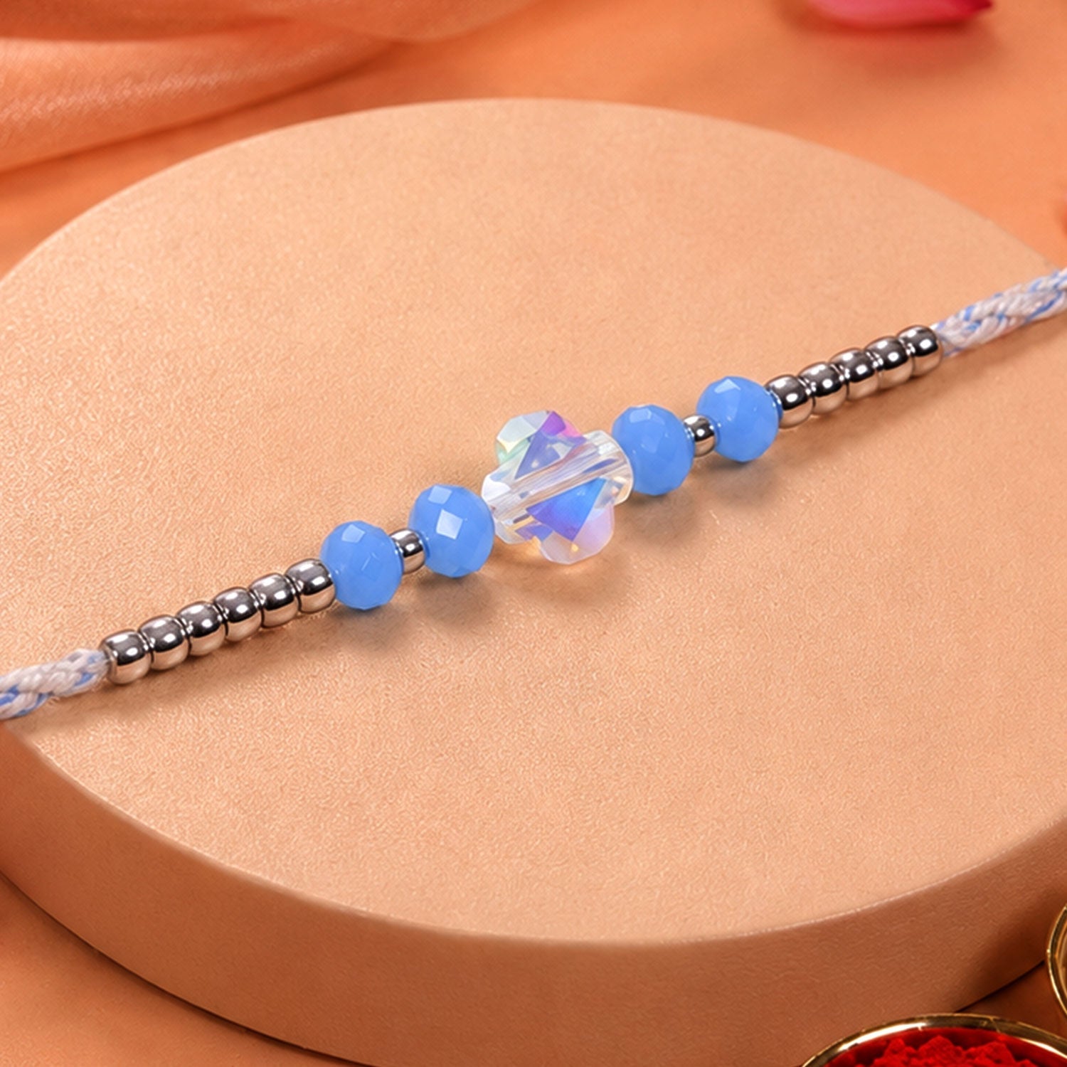 ALVENZA Blue Crystal Bead Rakhi with Round Stone Centre, Silver Highlights and Red Thread