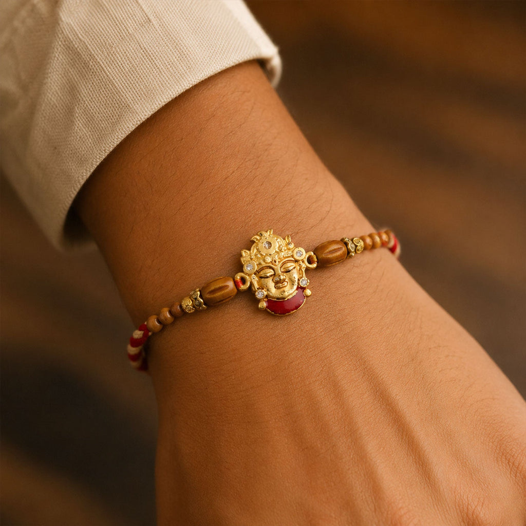 ALVENZA Golden Shrinathji Face Rakhi with Red Enamel Detail, Sandalwood-Finish Beads
