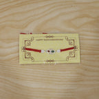 ALVENZA Silver Oval Rakhi – Elegant Design with Red Thread