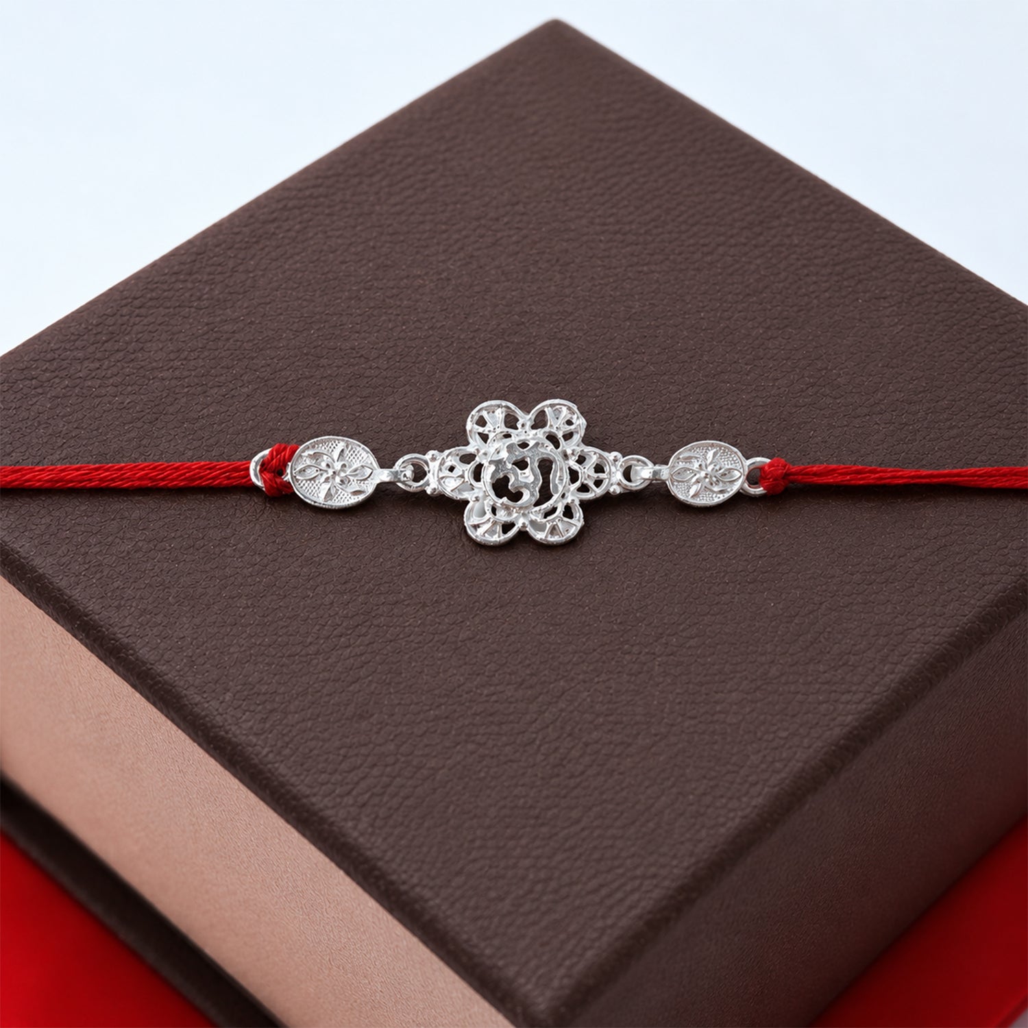 ALVENZA Silver Floral Om Rakhi – Elegant Red Thread for Rakshabandhan