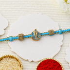 ALVENZA Turquoise Center Designer Rakhi with Gold Tone Detail and Elegant Bracelet Beauty